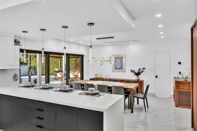 kitchen featuring decorative light fixtures, gray cabinets, and white cabinetry