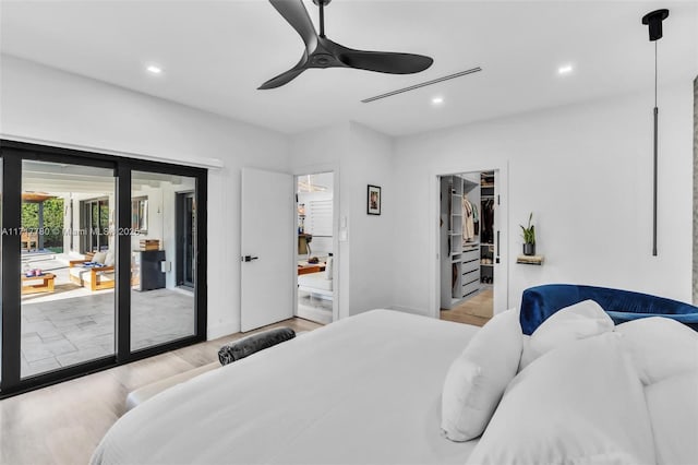 bedroom featuring access to exterior, light wood-type flooring, ceiling fan, a spacious closet, and a closet