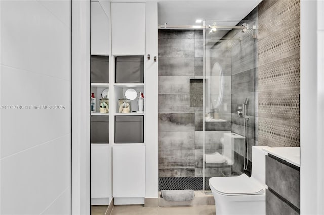 bathroom featuring a shower with door, vanity, and toilet