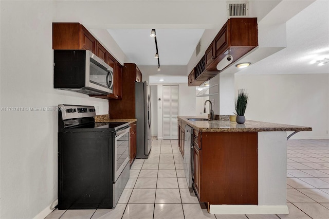 kitchen with kitchen peninsula, a kitchen breakfast bar, stainless steel appliances, sink, and light tile patterned floors