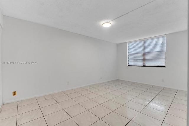 tiled spare room with a textured ceiling