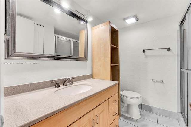 bathroom featuring tile patterned floors, toilet, vanity, and walk in shower