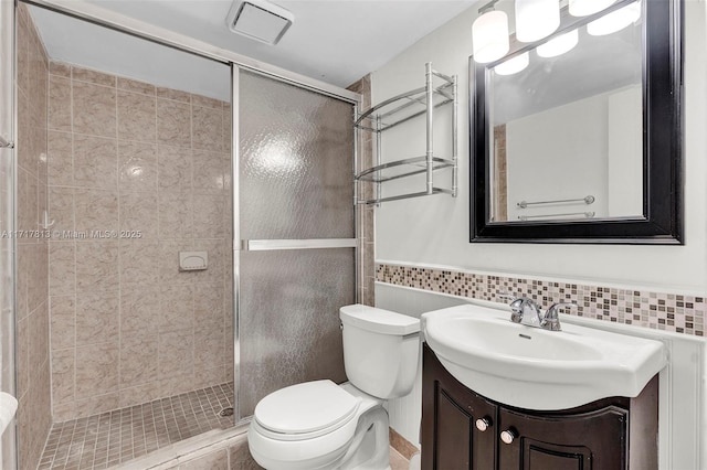 bathroom with vanity, toilet, walk in shower, and tile walls