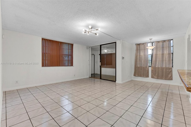 tiled empty room with a textured ceiling