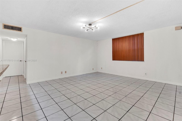 tiled spare room with a textured ceiling