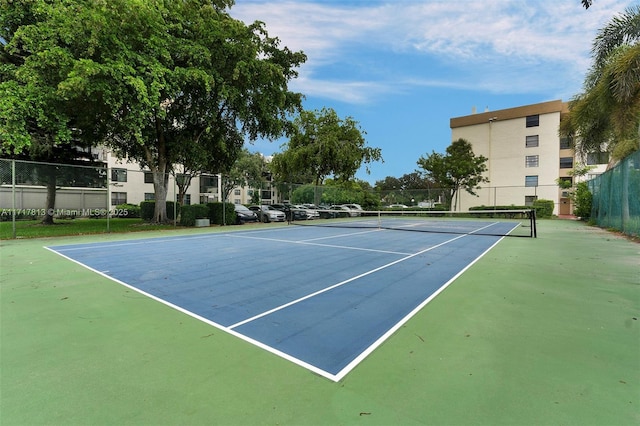 view of tennis court with basketball hoop