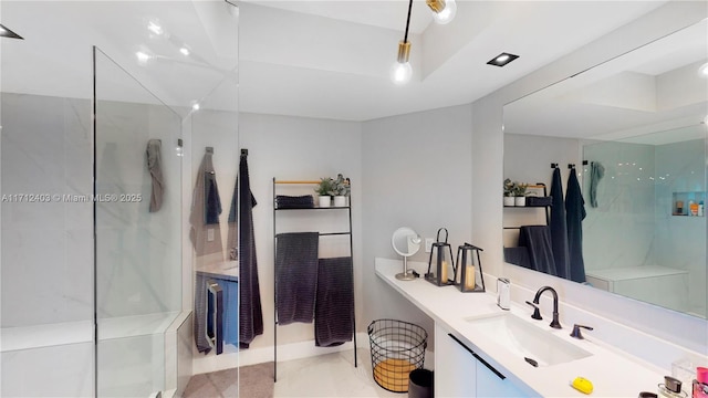 bathroom featuring a tile shower and vanity