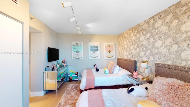 bedroom featuring light hardwood / wood-style floors and track lighting