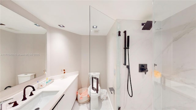 bathroom with a shower, vanity, and toilet