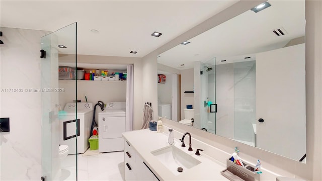 bathroom featuring walk in shower, washer and clothes dryer, vanity, and toilet