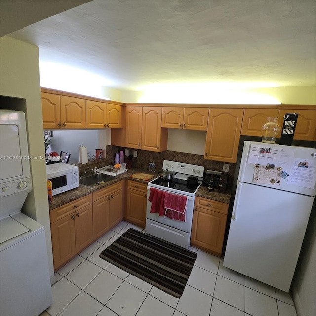 kitchen with white appliances, backsplash, sink, light tile patterned flooring, and stacked washer / dryer