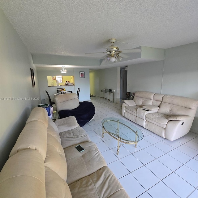 tiled living room featuring a textured ceiling and ceiling fan