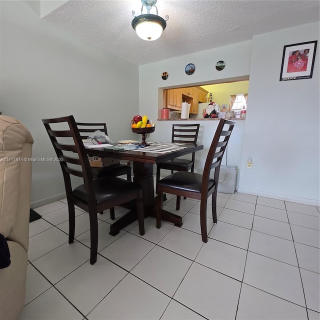 dining area with light tile patterned floors and a textured ceiling