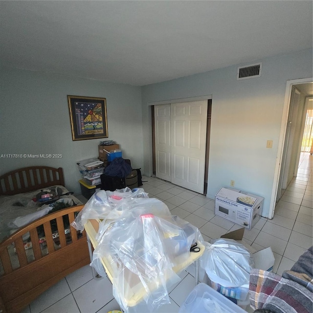 bedroom with light tile patterned flooring and a closet