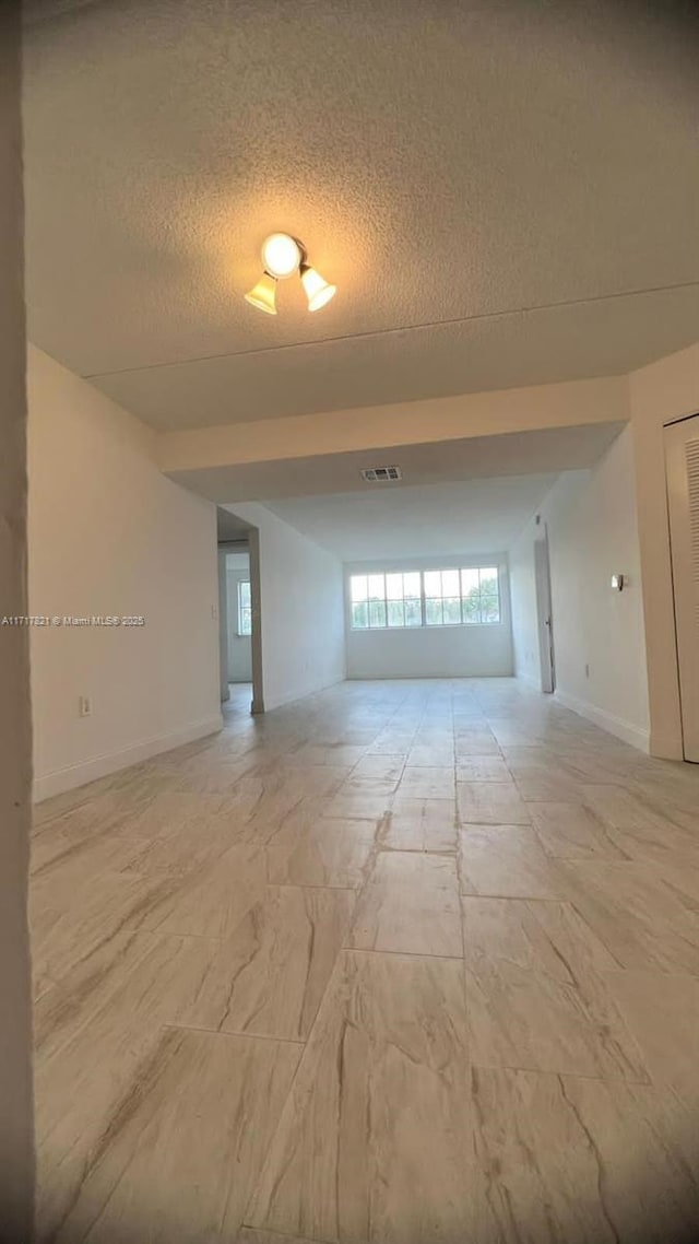 unfurnished room featuring a textured ceiling