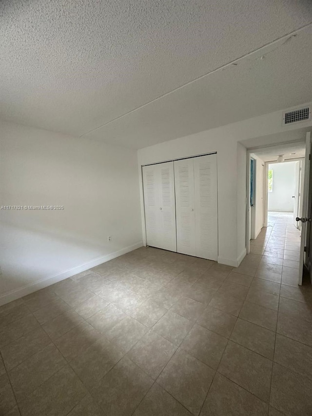 unfurnished bedroom with a textured ceiling and a closet