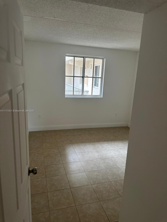 tiled spare room with a textured ceiling