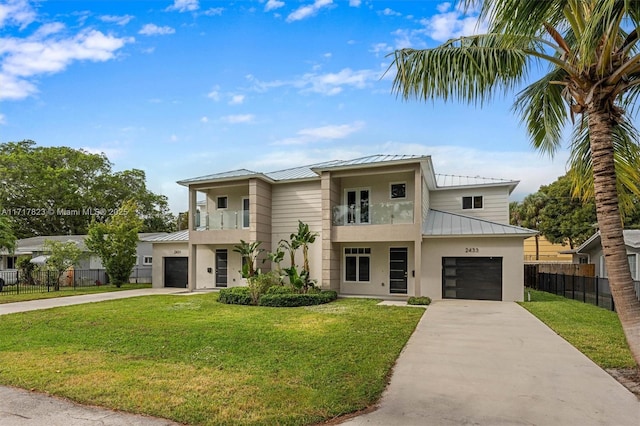 view of front of property featuring a garage, a balcony, and a front yard