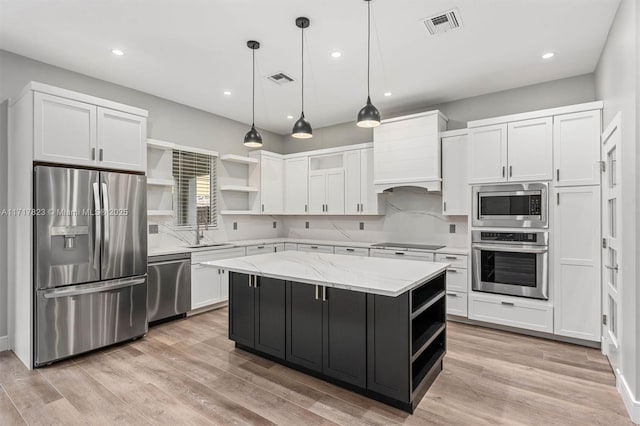 kitchen featuring white cabinets, a kitchen island, stainless steel appliances, and hanging light fixtures