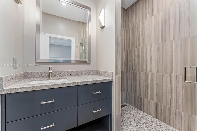 bathroom with vanity and a tile shower