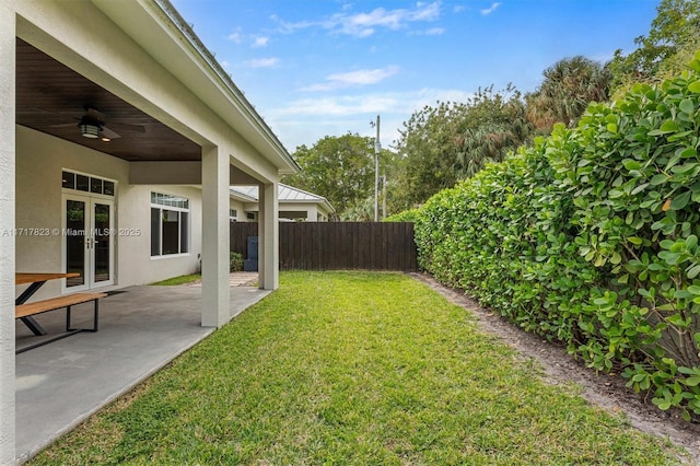 view of yard featuring ceiling fan, a patio, and french doors