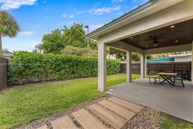 view of yard featuring ceiling fan and a patio