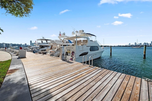 view of dock with a water view and a view of city