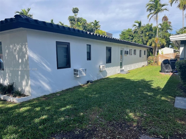 view of home's exterior with a yard and a wall mounted AC