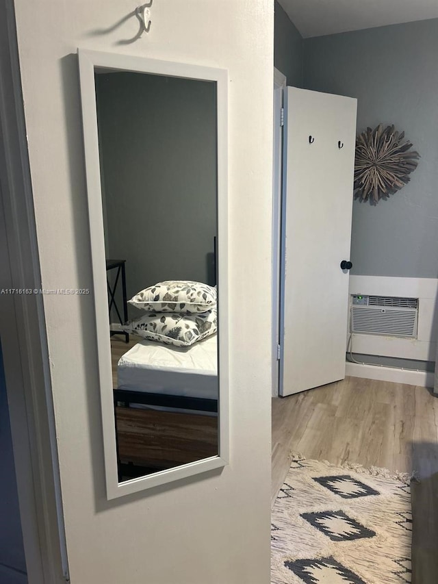 bathroom featuring a wall unit AC and hardwood / wood-style floors