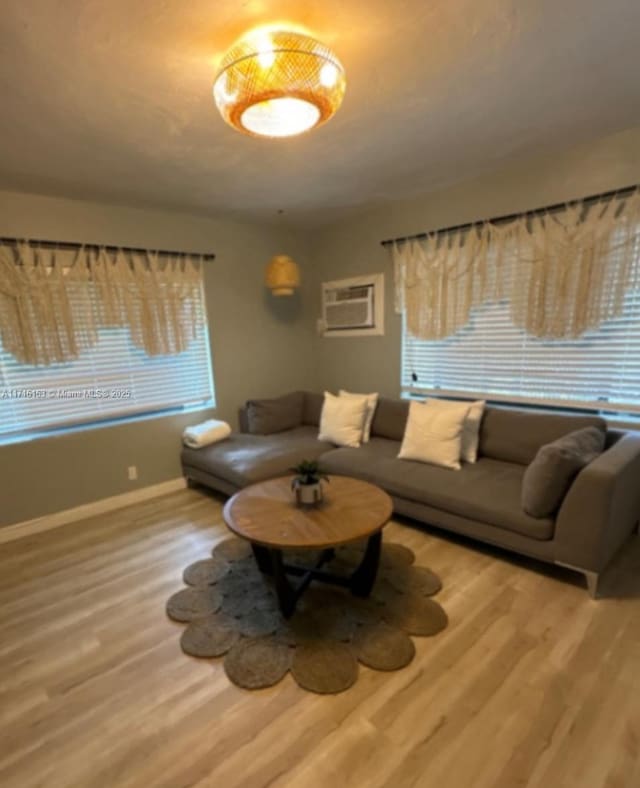 living room with hardwood / wood-style floors and an AC wall unit