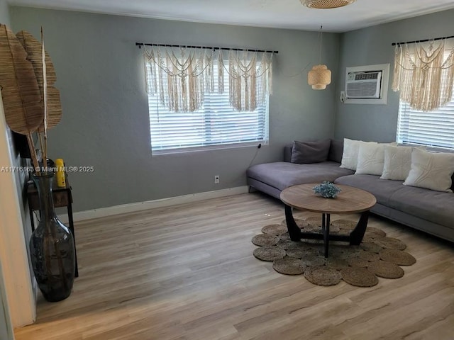 living room featuring ceiling fan, light hardwood / wood-style flooring, and a wall mounted AC