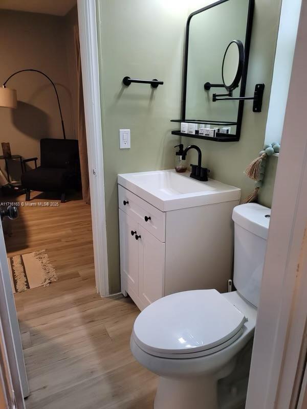 bathroom featuring hardwood / wood-style floors, vanity, and toilet