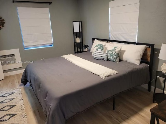 bedroom featuring a wall mounted air conditioner and light hardwood / wood-style floors