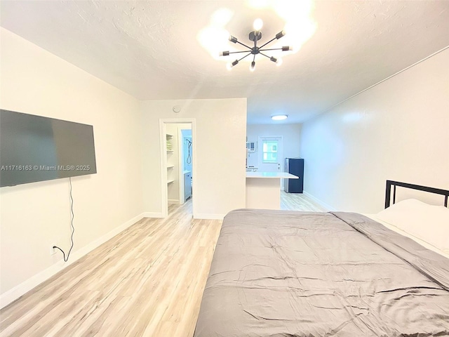 unfurnished bedroom featuring a walk in closet and light wood-type flooring