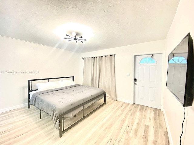 bedroom with a textured ceiling and light wood-type flooring