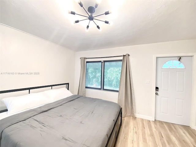 bedroom featuring a chandelier and light wood-type flooring