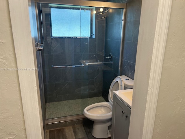 bathroom featuring hardwood / wood-style floors, vanity, toilet, and an enclosed shower