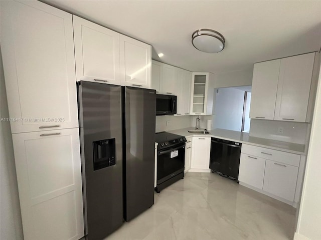 kitchen with sink, white cabinets, and black appliances