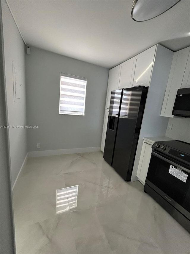 kitchen with black range with electric cooktop, white cabinetry, baseboards, light countertops, and stainless steel refrigerator with ice dispenser