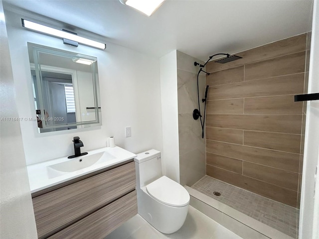 bathroom featuring tiled shower, vanity, and toilet