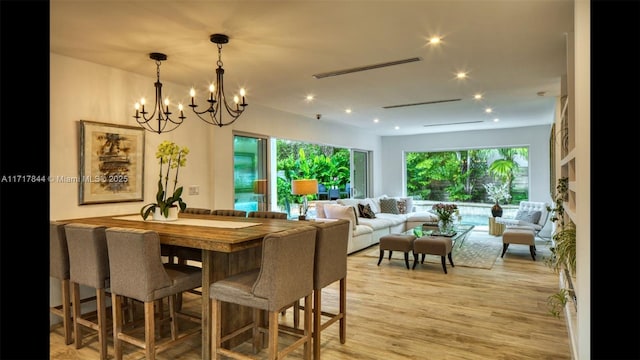 dining space featuring light hardwood / wood-style floors and a notable chandelier