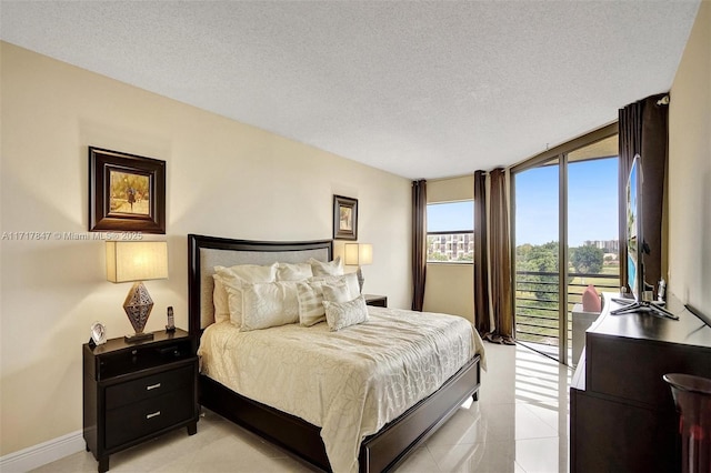 bedroom with expansive windows, access to exterior, and a textured ceiling