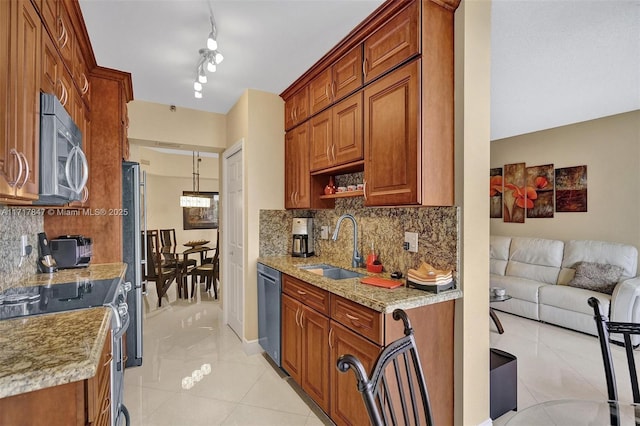 kitchen with light stone countertops, tasteful backsplash, stainless steel appliances, sink, and light tile patterned floors