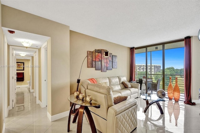 living room with a wall of windows, a textured ceiling, and light tile patterned floors