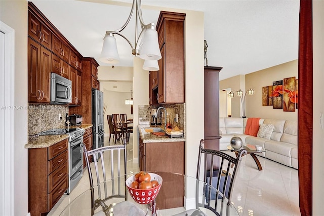 kitchen featuring decorative backsplash, sink, light stone counters, and appliances with stainless steel finishes