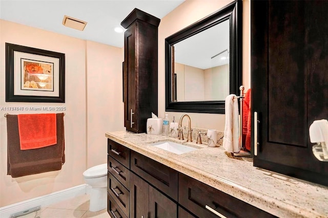 bathroom with tile patterned flooring, vanity, and toilet