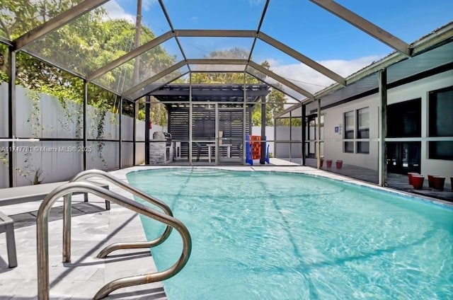 view of swimming pool with glass enclosure and a patio