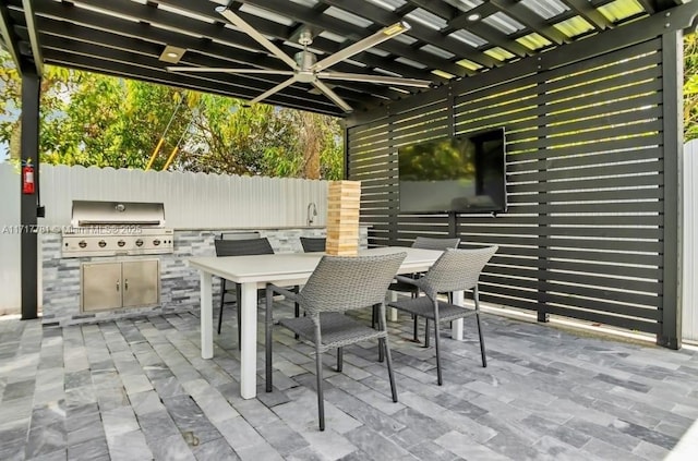 view of patio featuring an outdoor kitchen, area for grilling, and ceiling fan