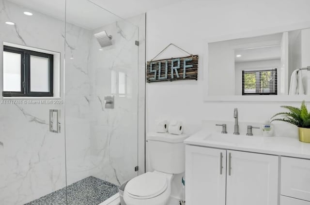 bathroom with vanity, a shower with shower door, and toilet