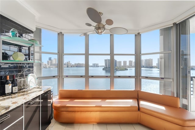 sunroom / solarium featuring a water view and a healthy amount of sunlight